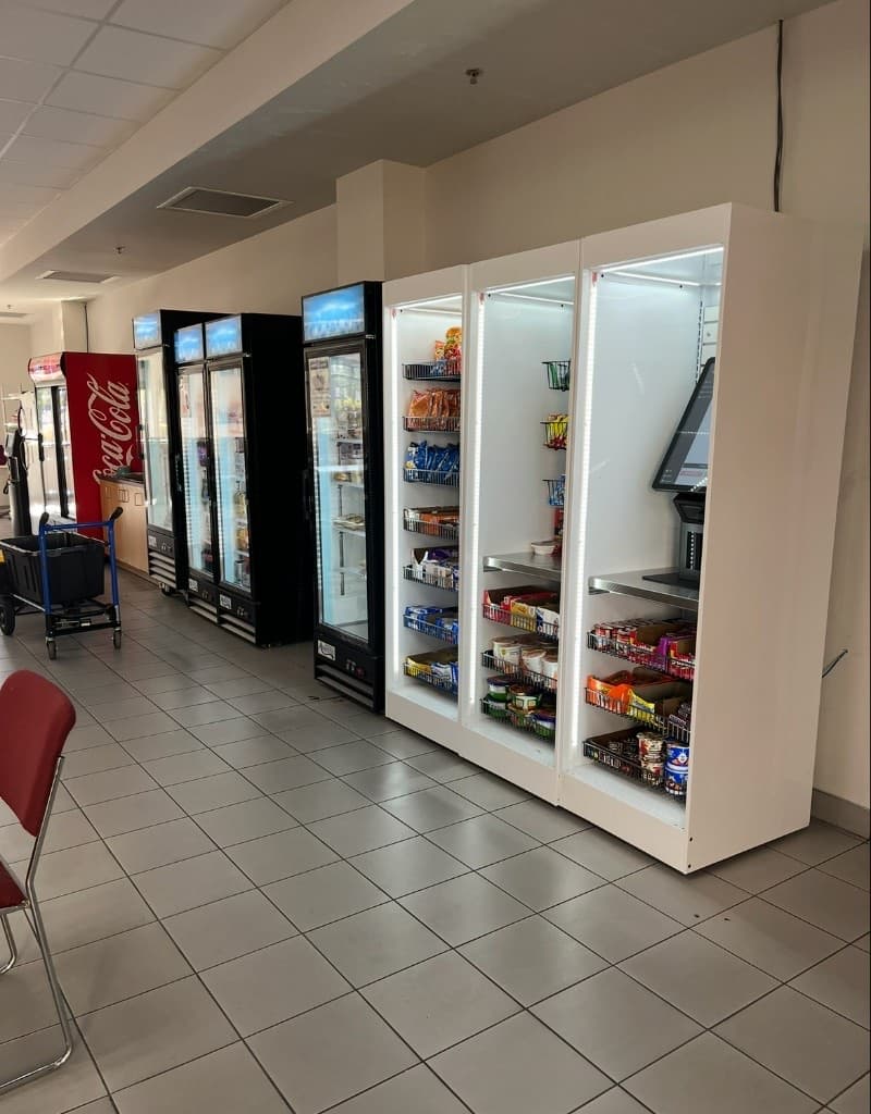 Jacksonville breakroom micro-market with refrigerated cases, illuminated open snack shelves, and a self-checkout kiosk